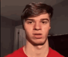 a man in a red shirt is making a funny face .