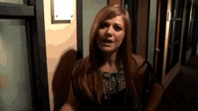 a woman is standing in a hallway with a sign on the wall that says ' a ' on it