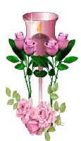a candle in a glass with pink roses around it