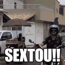 a man is riding a motorcycle down a street with the words sextou written on the side .