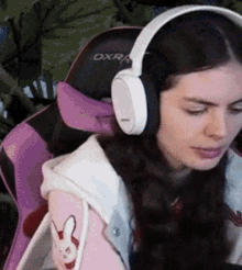 a woman wearing headphones is sitting in a chair with the word dxra on it