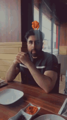 a man is sitting at a table with a plate of food