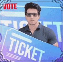 a man wearing sunglasses holds a blue ticket in front of a blue background that says vote
