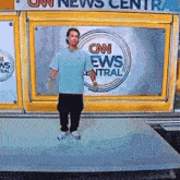 a man standing in front of a cnn news center sign