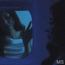 a woman is looking at herself in a mirror with the letters ms below her