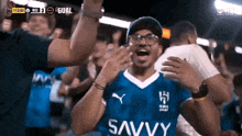 a man in a blue shirt that says savvy