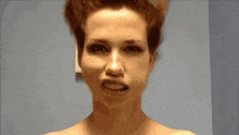 a woman without a shirt is making a funny face with her mouth open