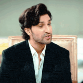 a man wearing a black jacket and white shirt