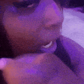 a close up of a person 's face with purple lights behind them