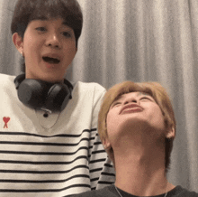 a man wearing headphones is standing next to another man