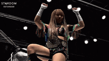 a female wrestler stands in front of a sign that says stardom #stardom