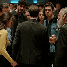 a group of people are standing in a dark room and holding hands