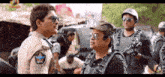 a man in a police uniform is talking to another man in a military uniform