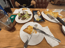 a person is sitting at a table with plates of food and a can of pepsi