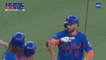 a new york mets player high fives another player on the field