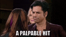 a man in a suit talks to a woman with the words " a palpable hit " written on the bottom