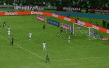 a man in a yellow shirt that says club on it watches a soccer player on the field