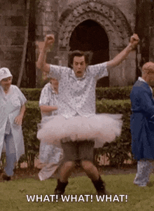a man is wearing a tutu and dancing in a park with other people .