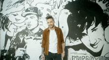 a man stands in front of a wall with a drawing of a man and a woman and the word everybody