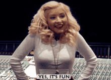 a woman stands in front of a mixer with a sign that says yes it 's fun