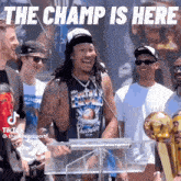 a man is standing at a podium with a microphone in front of a crowd of people holding trophies .