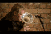 a man playing a trombone in front of a microphone