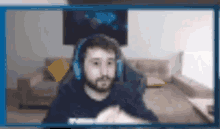 a man wearing headphones is sitting in front of a computer screen .