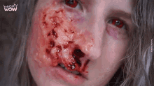 a close up of a woman 's face with blood on it