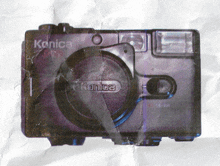 a purple konica camera is on a piece of crumpled paper
