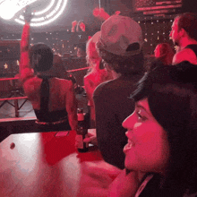 a woman sitting at a bar with a bottle of budweiser in her hand
