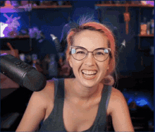 a woman wearing glasses and horns is laughing in front of a microphone