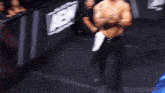 a man without a shirt is standing in front of a sign that says aew