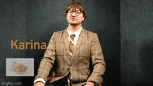 a man in a suit and tie is sitting in front of a wall with the name karina on it
