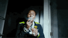 a man is smoking a cigarette in a dark room in a room .