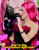 a woman with pink hair is singing into a microphone and says " am i jealous right now "