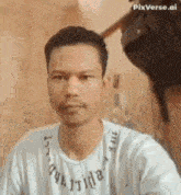 a man with a beard is taking a selfie with his phone while wearing a white shirt .