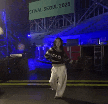 a woman in a striped sweater and white pants is dancing