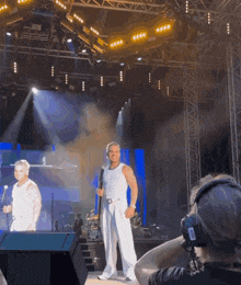 a man stands on stage holding a microphone