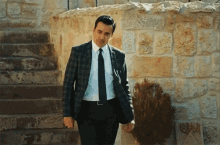 a man in a suit and tie is walking down a set of stairs