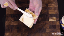 a person is spreading butter on a piece of bread on a cutting board
