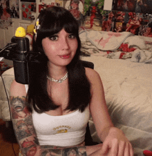 a woman is sitting in front of a microphone in her bedroom .