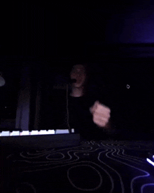 a person giving the middle finger in front of a piano keyboard