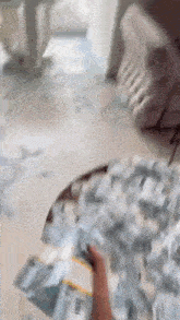 a person is holding a pile of money on a table in a room .