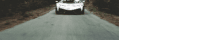 a car is driving down a road with trees on both sides