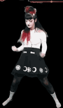 a woman with red hair is wearing a black skirt with the moons on it