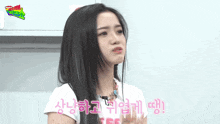 a girl with long black hair is making a funny face while talking to someone .
