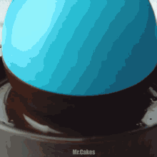 a blue balloon is floating in a bowl of chocolate with the words mr.cakes written on the bottom