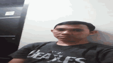 a man wearing a black shirt that says genesis on it