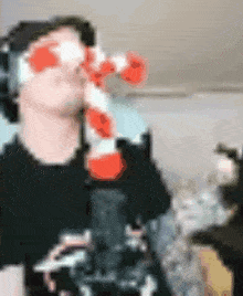 a man wearing headphones is drinking from a bottle with red hearts on it .