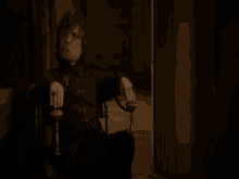 a man is sitting in a chair with his hands on his hips